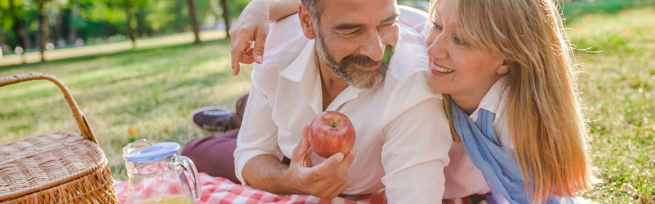 Man and woman smiling while on a picnic